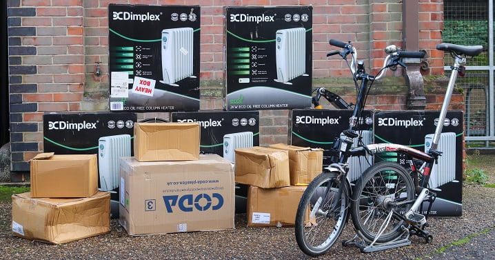 Black electric delivery bike beside a number of cardboard boxes